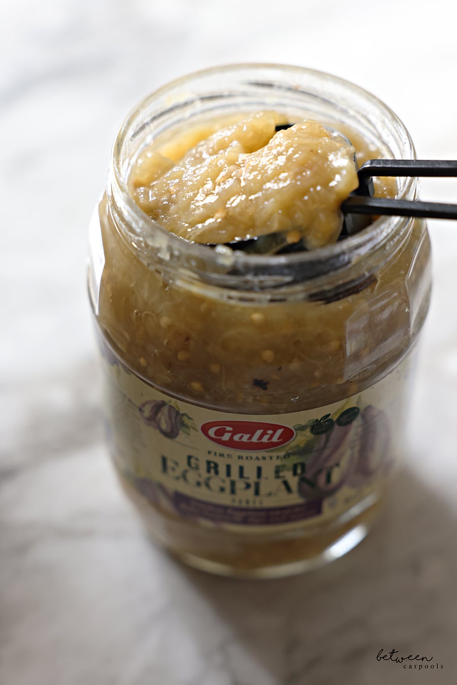 Removing half a cup from a jar of Galil fire roasted grilled eggplant.