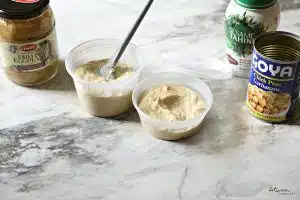 Galil grilled eggplant, 16 oz plastic deli container with Chummus Ganush, 8 oz container with chummus, sesame tahini and an empty can of Goya chick peas.
