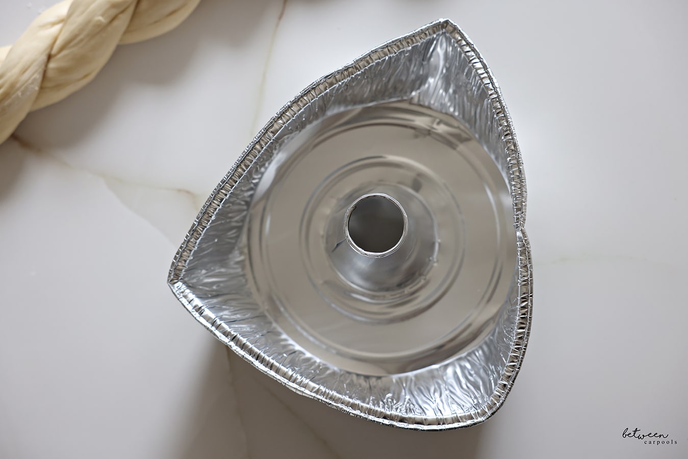 The sides of a 10" aluminum foil tube pan bent in to resemble a triangle.