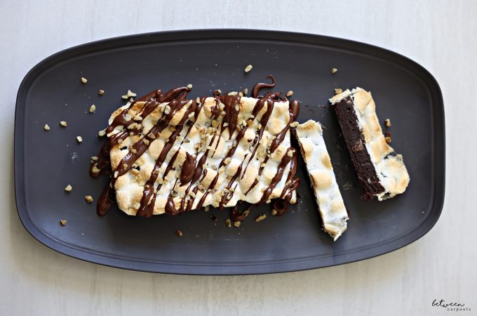 Rocky Road Marshmallow Brownie loaf on a platter with Almond Butter Ganache topping and walnut nibs.