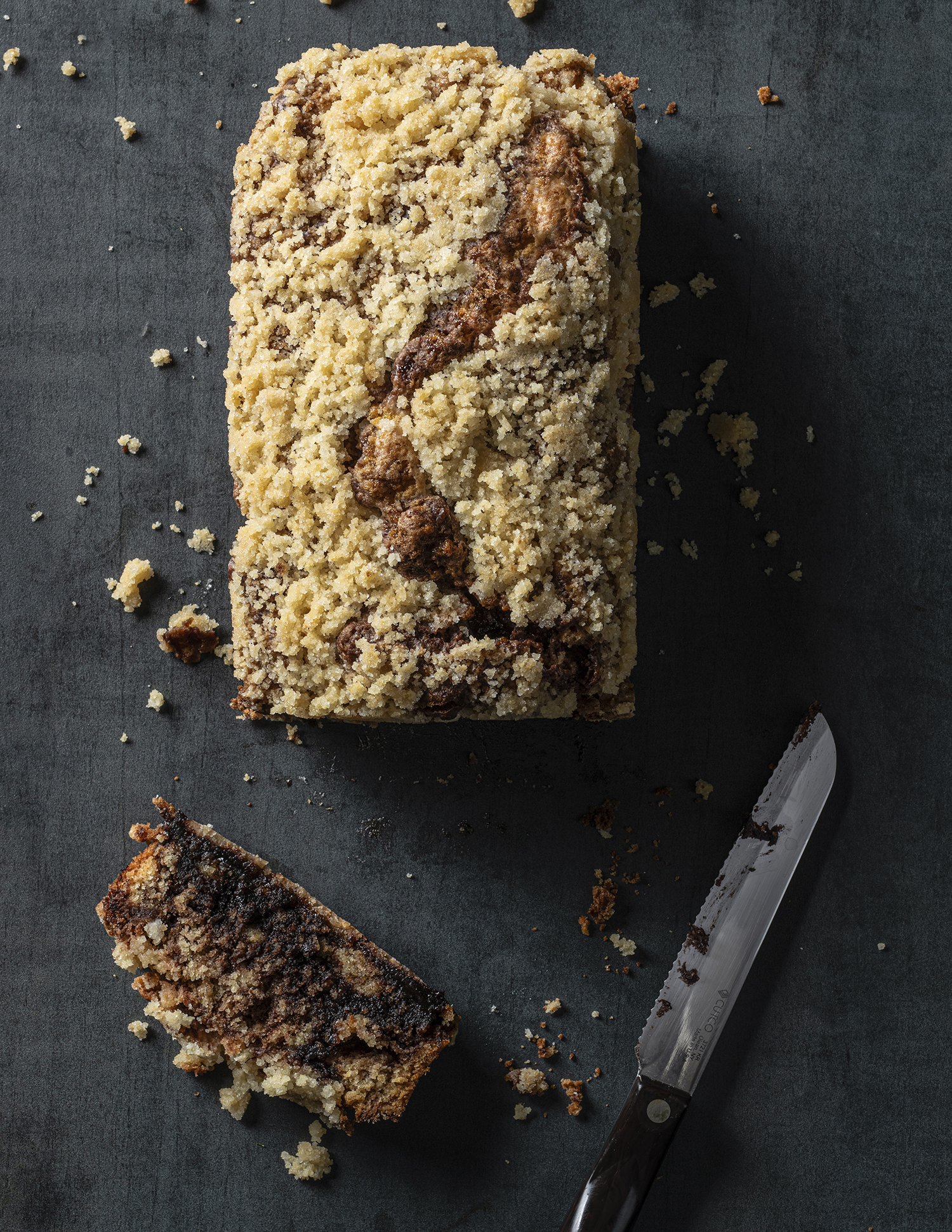 Meltaway Babka on dark background with one cut slice and a Cutco knife. From Rivky Kleiman's Simply Pesach and Beyond cookbook.