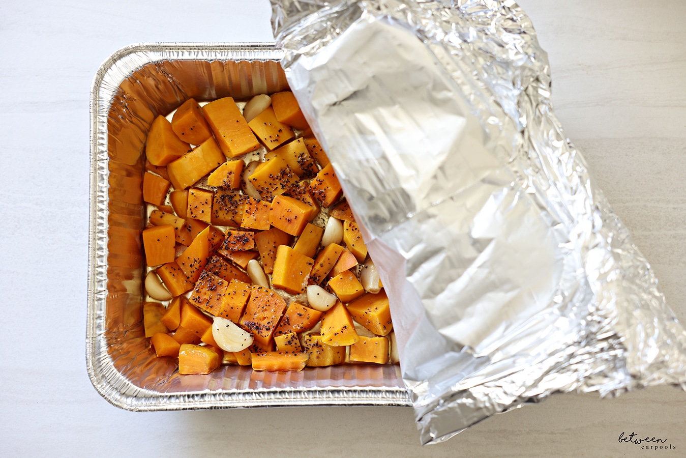A 9x13 pan with sweet potato chunks, whole garlic cloves, oil, salt and pepper, baked until soft.