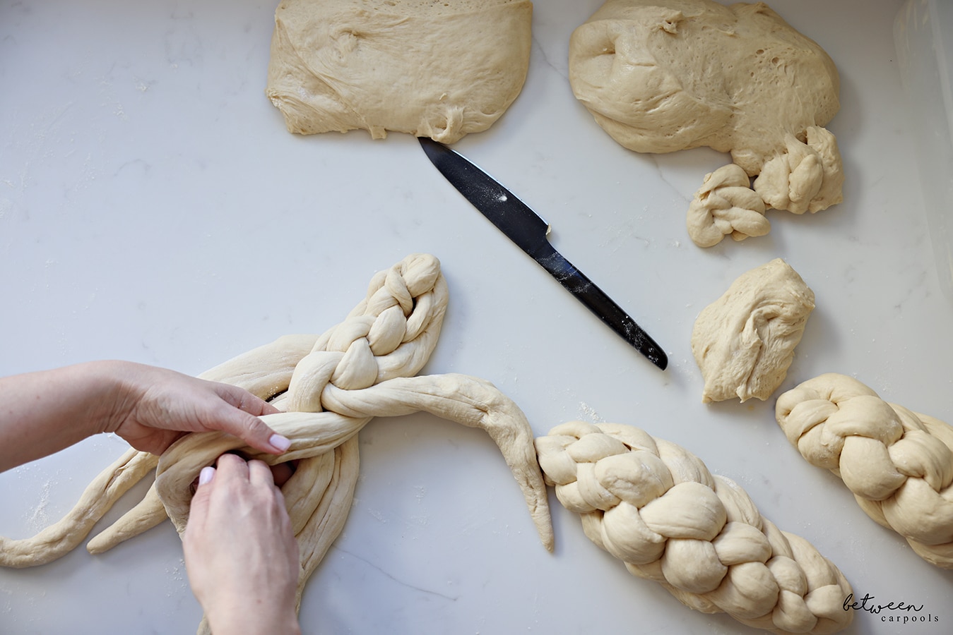 Braiding a 6 strand challah on a kitchen counter.