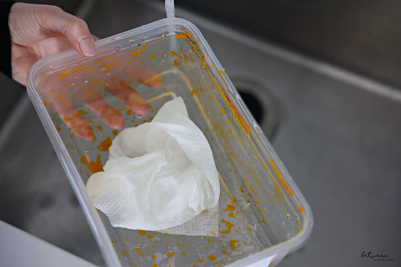 A wet piece of paper towel with dish soap in a dirty container from Meatballs.