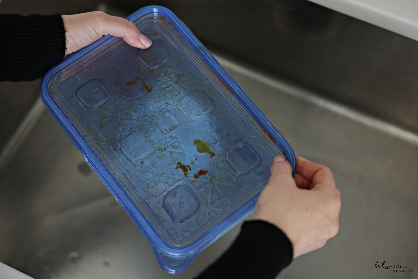 Closing the lid of a dirty container from Meatballs with a wet piece of paper towel with dish soap inside.