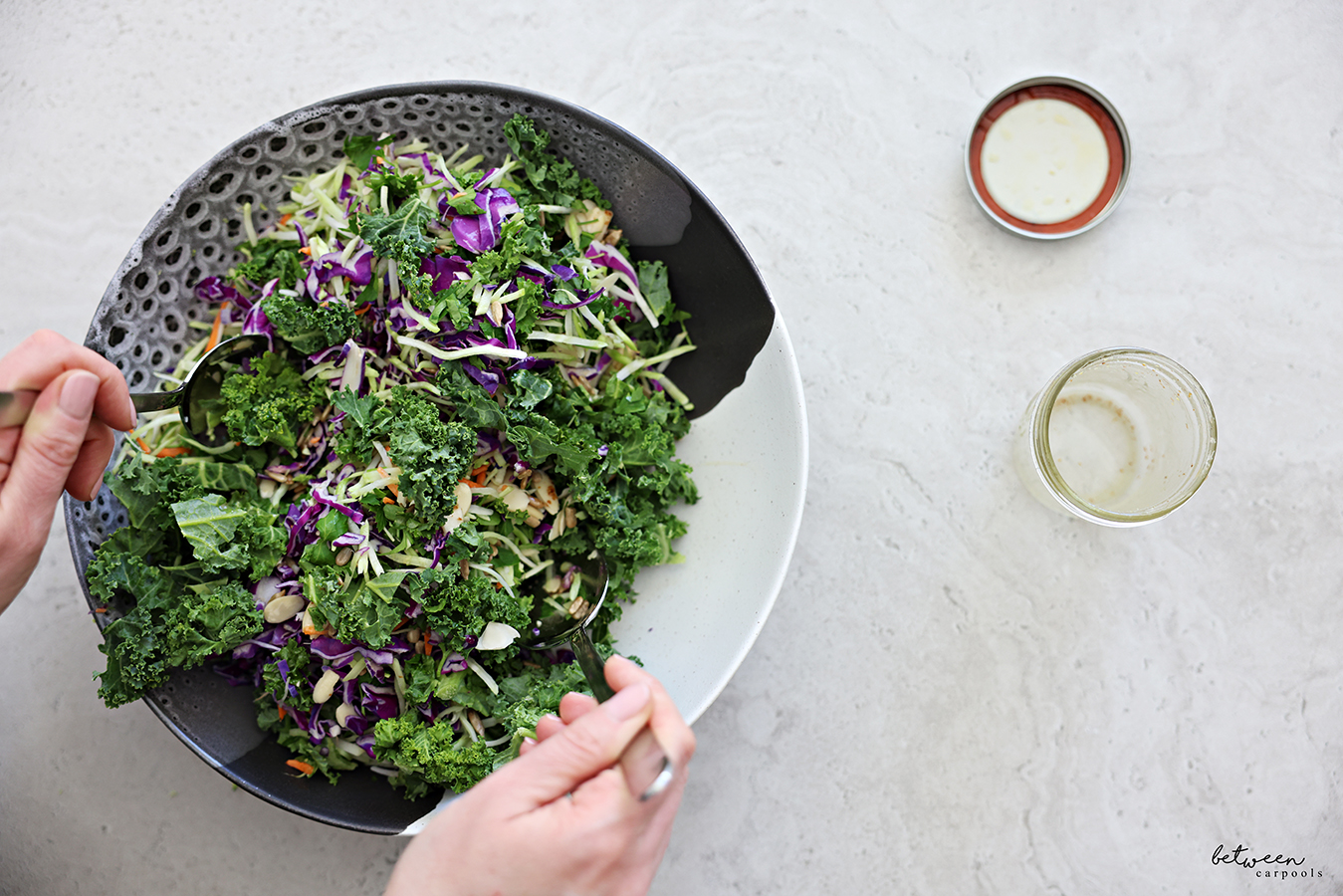 Tossing all salad components with lemon vinaigrette in a large salad bowl.