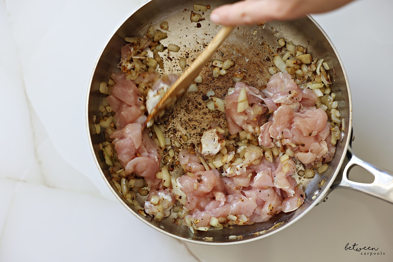 “Stir fry-sized” chicken cutlets in a sauté pan with sautéed Spanish onion and Pinch Busy Chicken Blend.