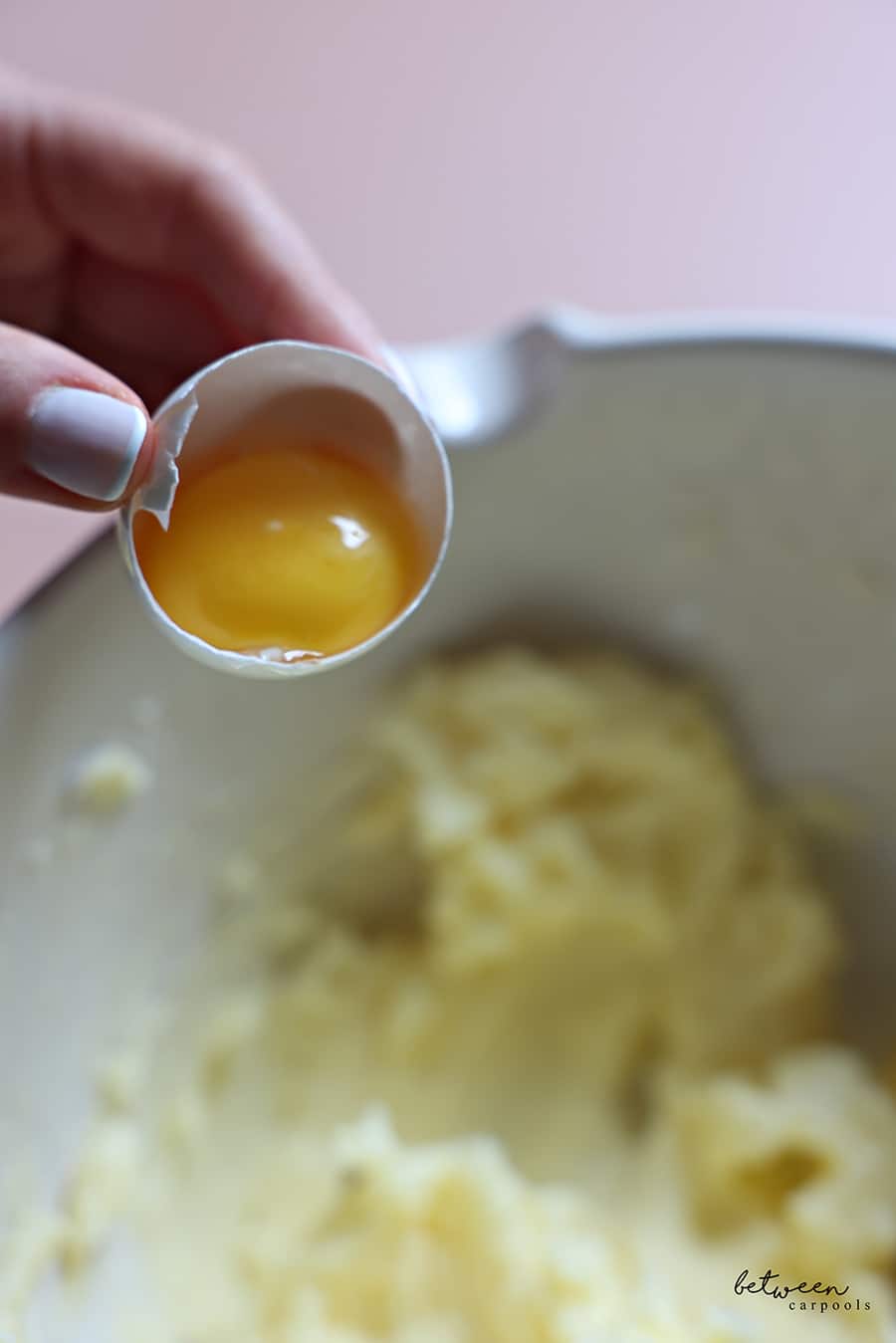 Adding an egg yolk to butter and confectioners sugar mixture.