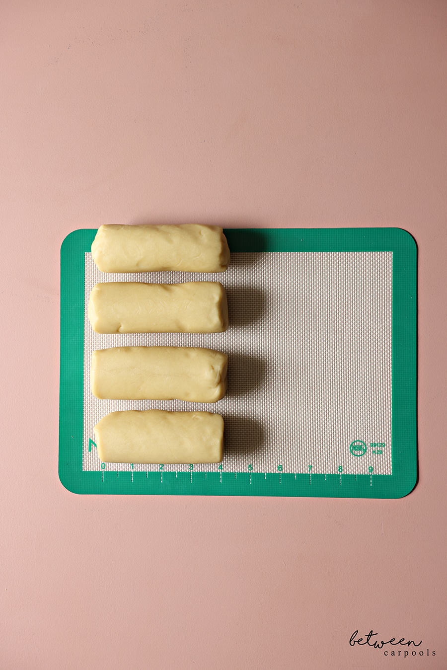 4 4" long logs of French Butter Cookie dough on a silicone baking mat.