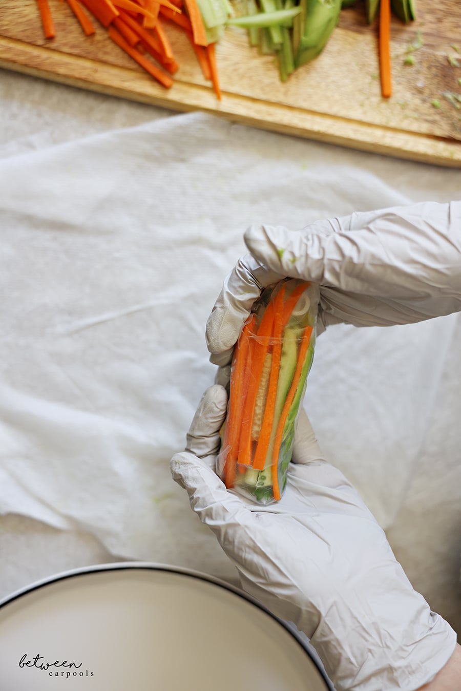 Holding a finished rolled rice paper with gloved hands.