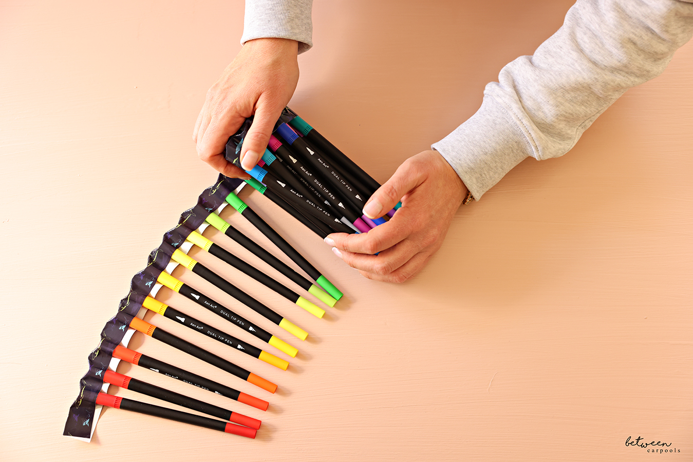 Rolling up a set of markers with its caps held together with duct tape.