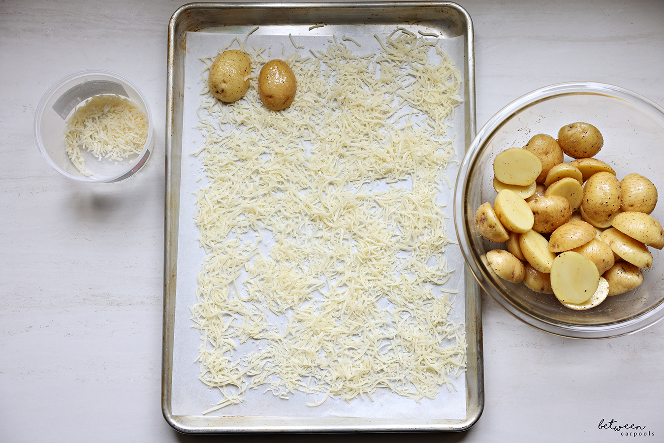 Hasselback baby potato halves in a bowl. Two potato halves on Parmesan cheese on a parchment lined sheet pan.