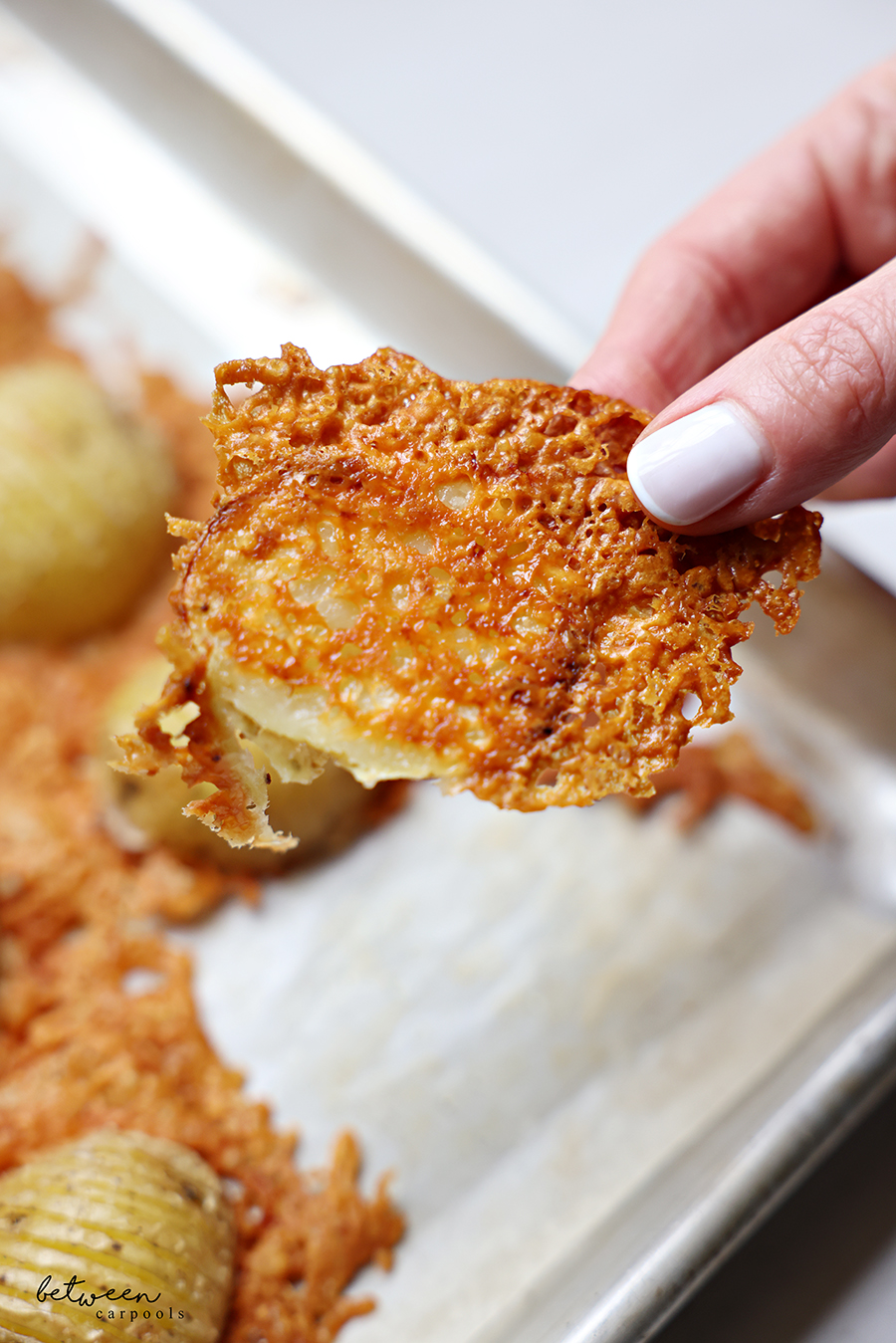 Holding a crispy Parmesan potato half.