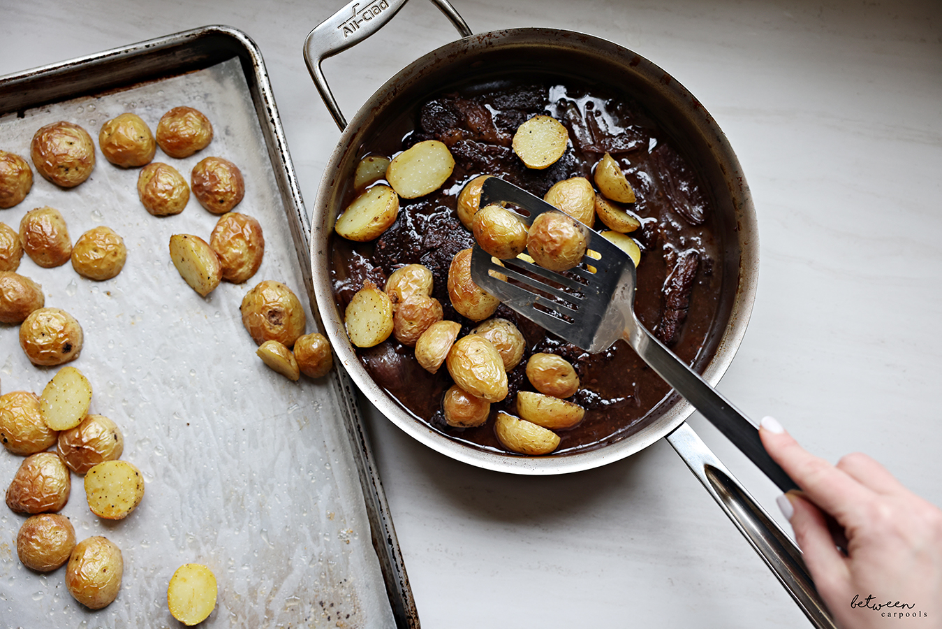 Adding baked baby yellow potato halves to the pot of boneless flanken and sauce.