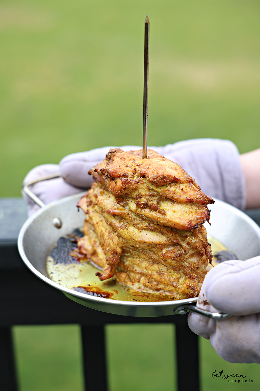 Holding an Al Pastor Vertical Skewer with grilled shawarma chicken.