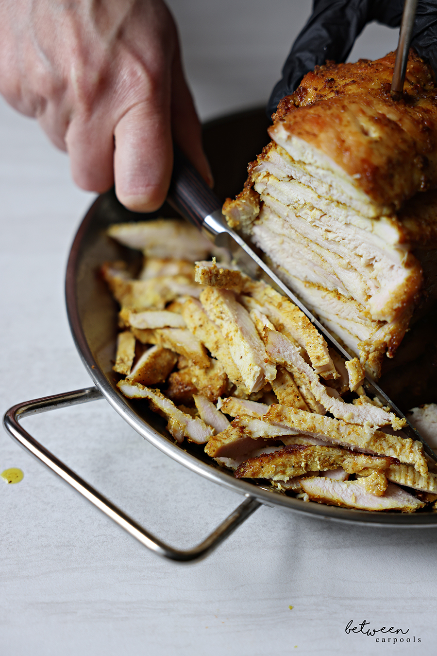 Slicing the shawarma chicken off the skewer of an Al Pastor Vertical Skewer.
