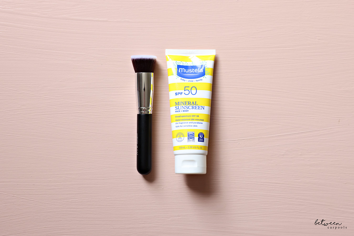 A Flat Top Kabuki Foundation Brush and a Mustela Mineral Sunscreen Lotion.