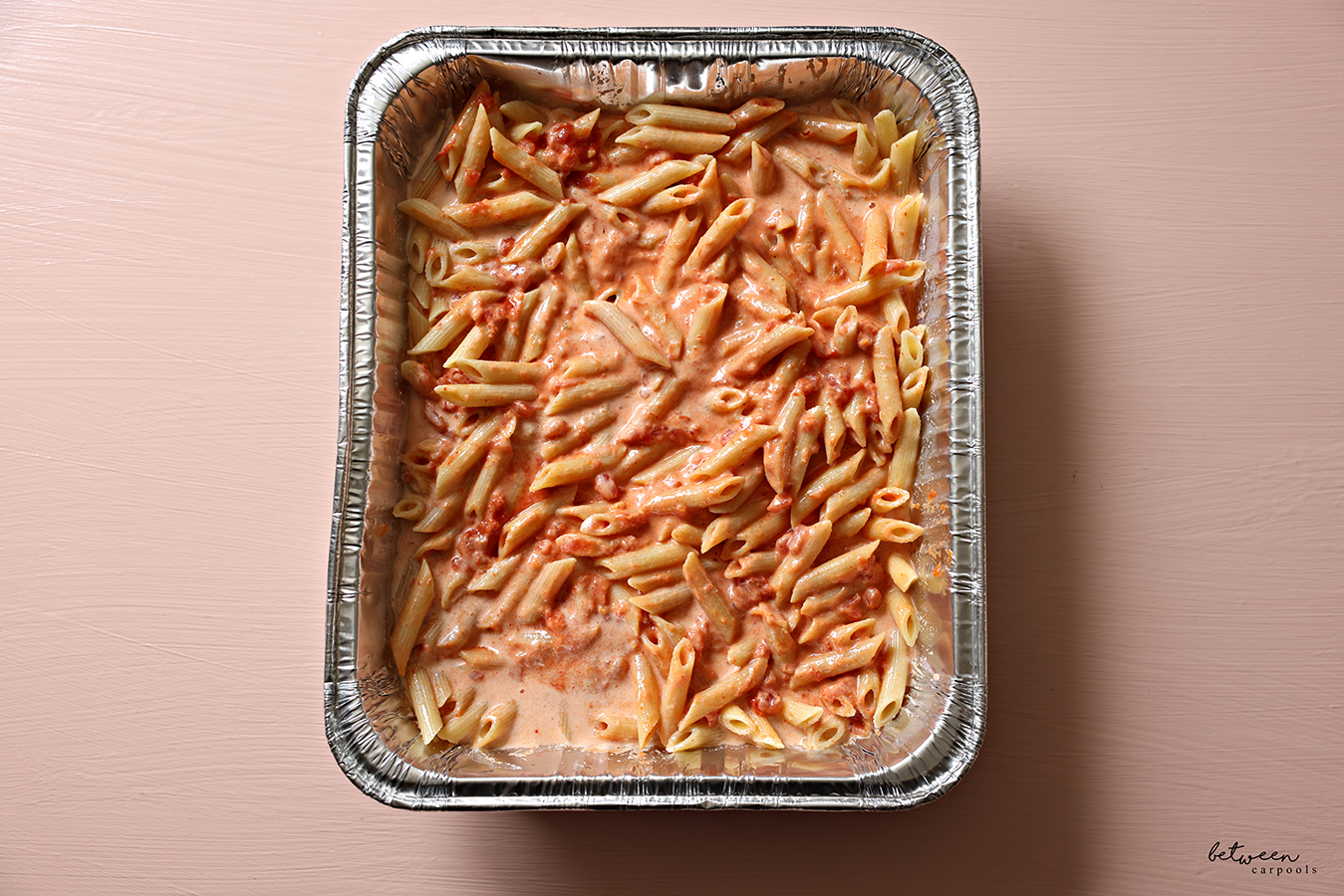 Cooked penne + marinara sauce, heavy cream and salt, in a 9x13-inch aluminum foil pan.