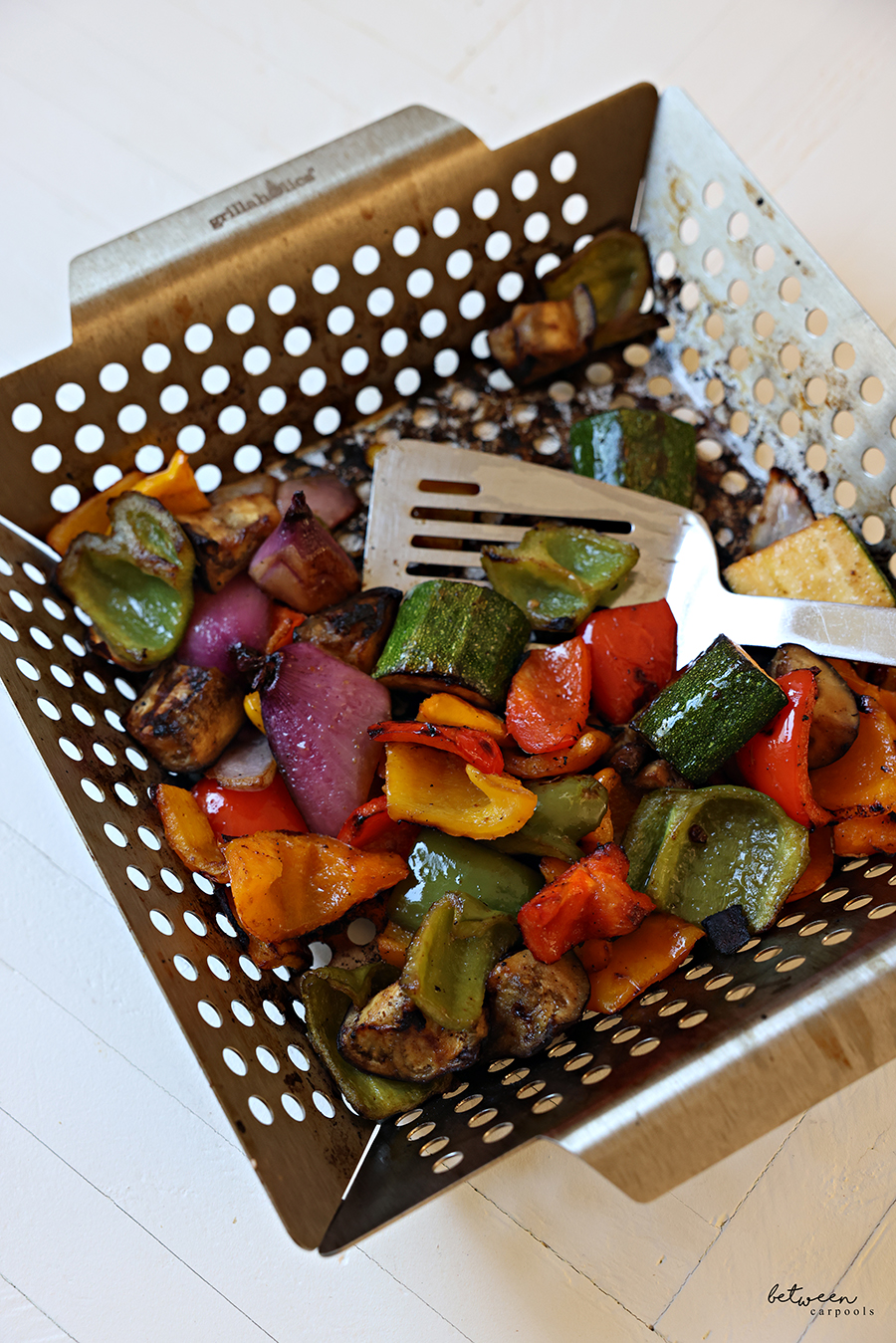 Grilled vegetables in a grill basket.