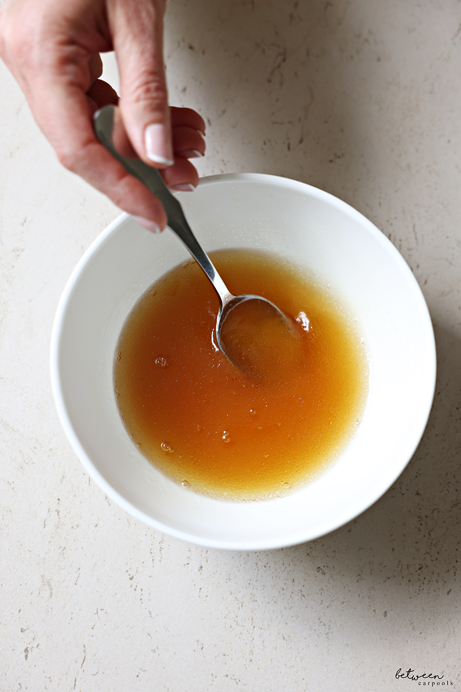 Mixing bourbon glaze in a small bowl.
