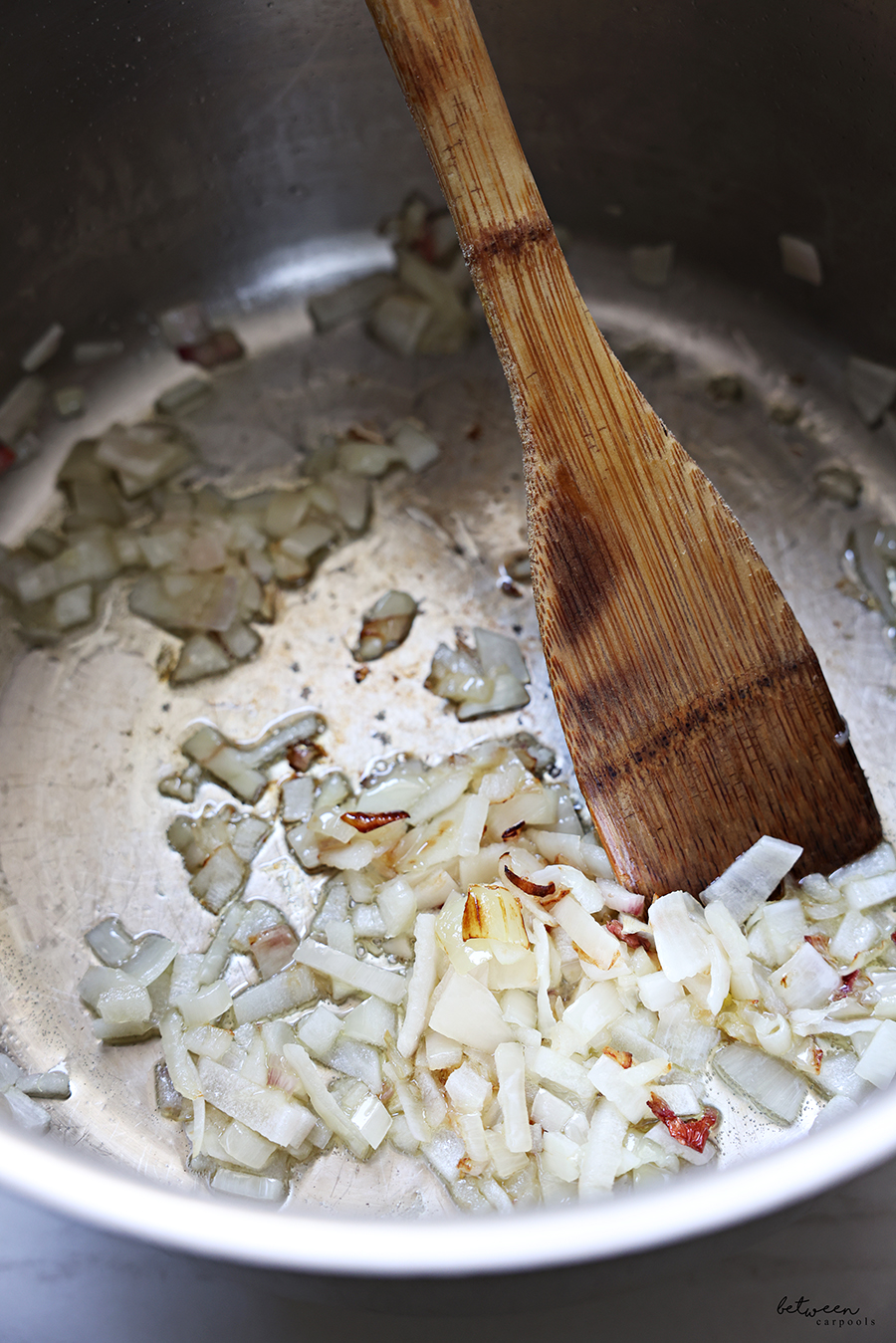 Sautéing a finely diced shallot in a sauté pan.