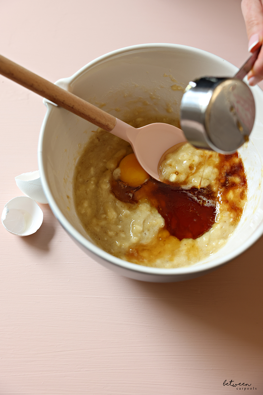 Wet ingredients with mashed banana in a mixing bowl.