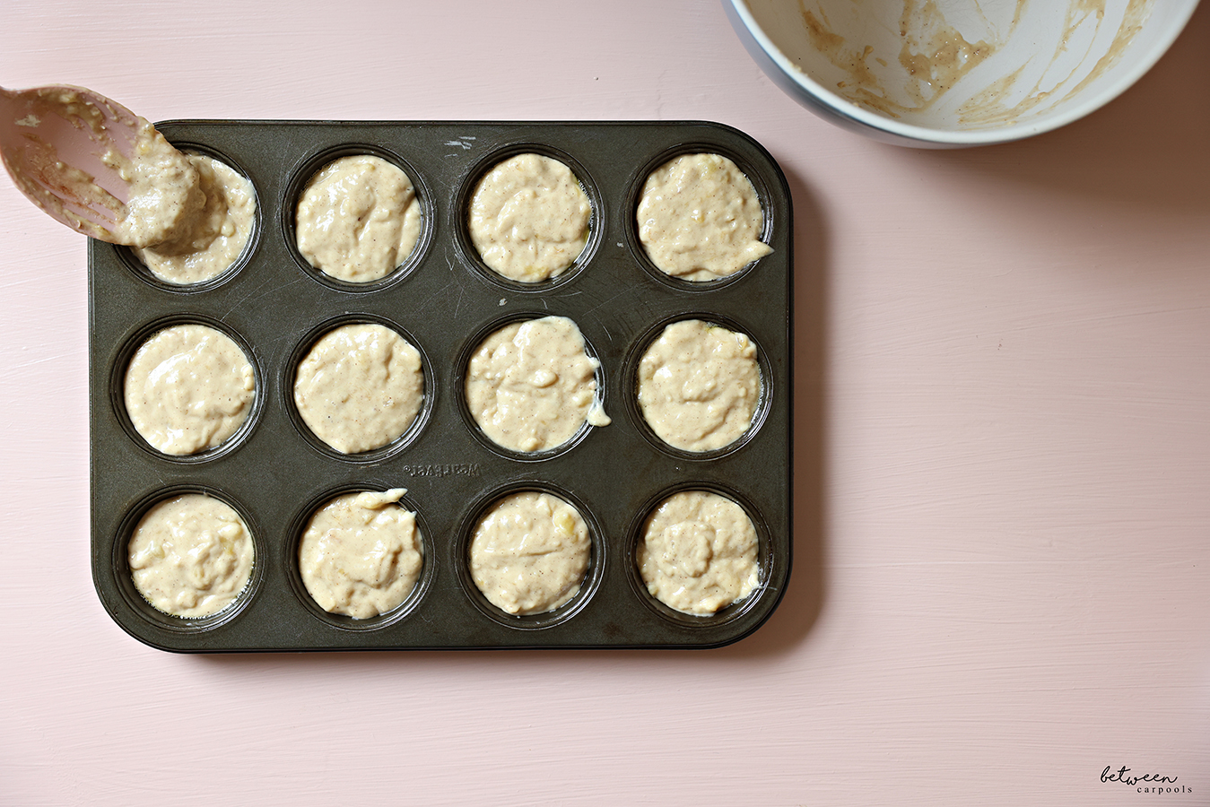 Banana muffin batter divided between the cups of a standard 12 cup muffin pan.